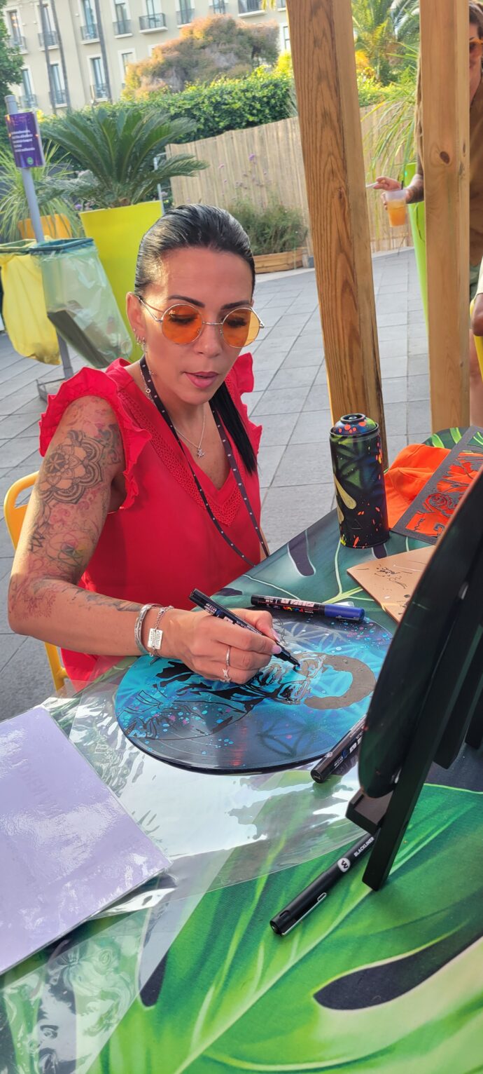 Florence Fabris animant un atelier de peinture sur vinyles avec des enfants et des adultes lors du Nice Jazz Festival 2025.