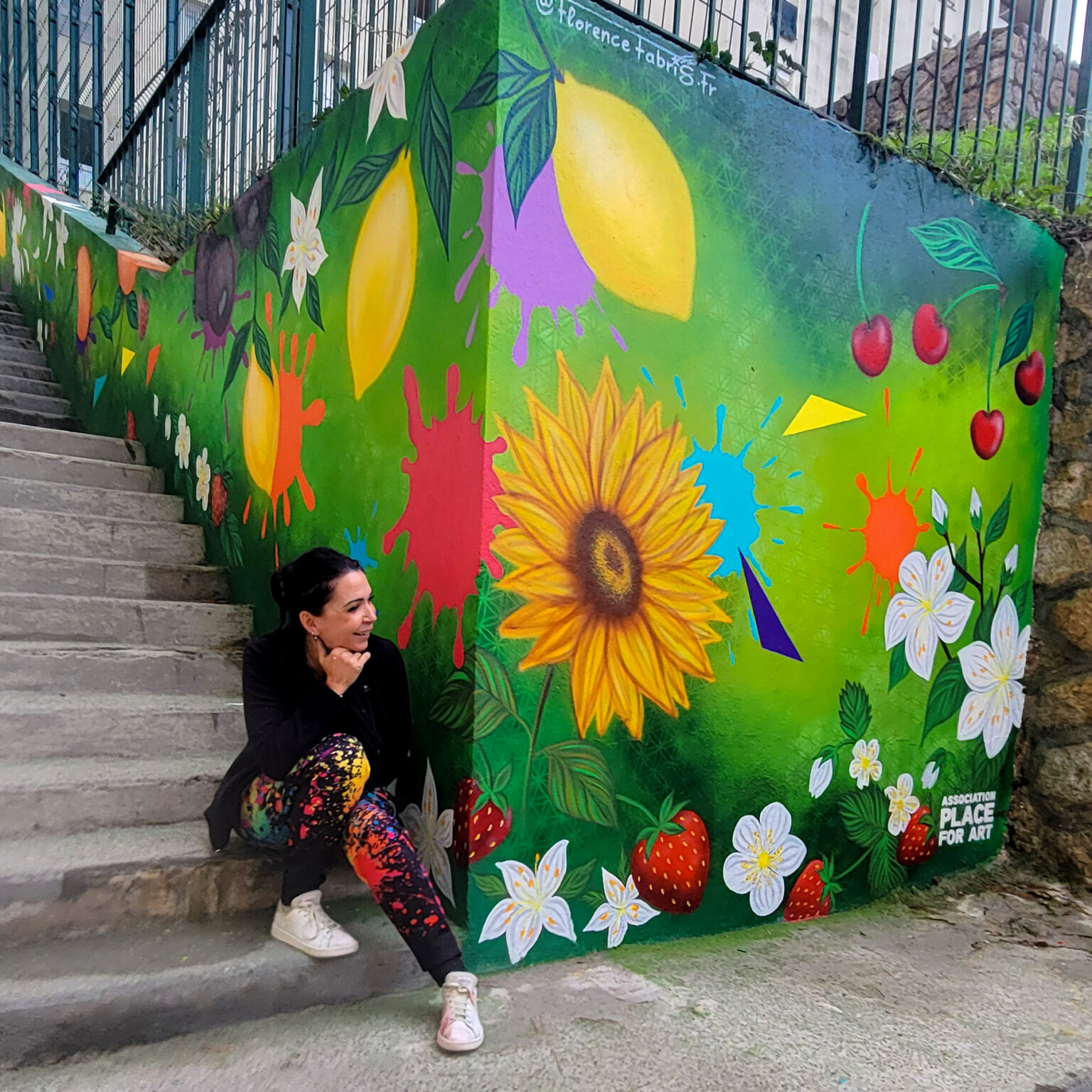 Florence Fabris entourée des adolescents et des participants devant la fresque colorée réalisée pour les jardins partagés de Carros.