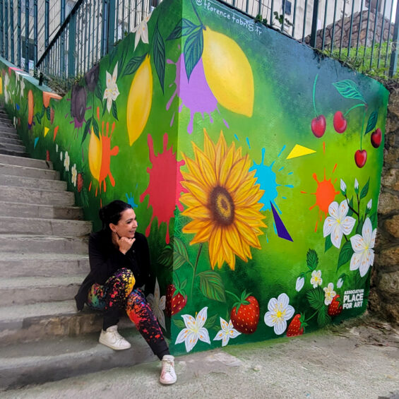 Florence Fabris entourée des adolescents et des participants devant la fresque colorée réalisée pour les jardins partagés de Carros.