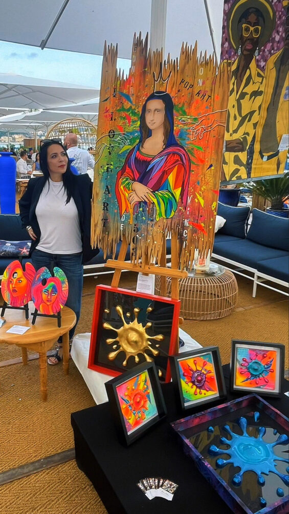 Florence Fabris présentant ses œuvres lors de la soirée de vernissage à la plage privée La Vela à Nice.